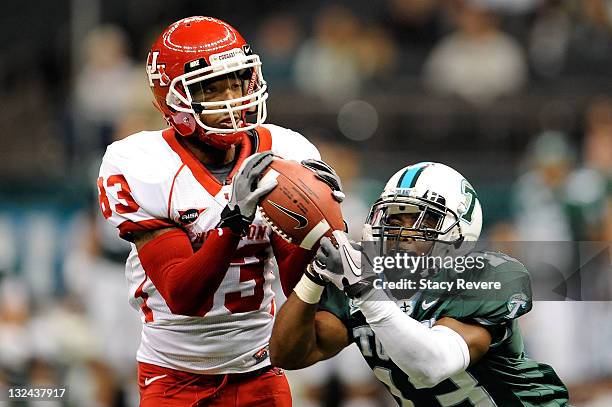 Patrick Edwards of the University of Houston Cougars catches a pass over Derrick Strozier of the Tulane Green Wave during a game being held at the...