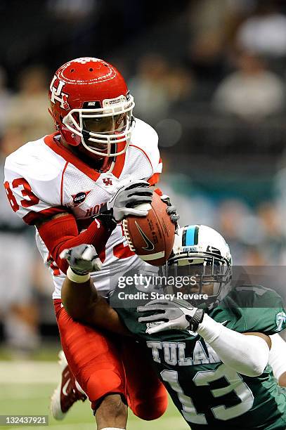 Patrick Edwards of the University of Houston Cougars catches a pass over Derrick Strozier of the Tulane Green Wave during a game being held at the...