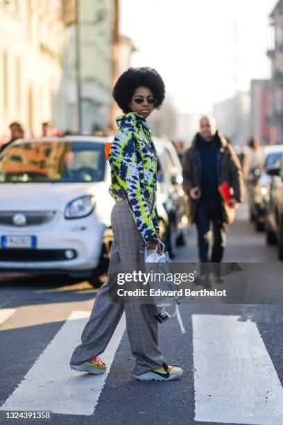 Guest wears vintage sunglasses, a blue neon yellow and white tie and dye Off-White short coat, gray and rend checkered large pants, a gray and white...