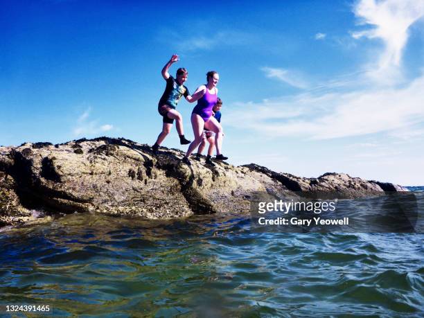 woman with children jumping into the sea - beach family jumping stock pictures, royalty-free photos & images