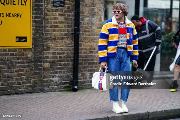 Guest wears pale pink futurist sunglasses, a pearl necklace, a gold chain with pendant necklace, a red with yellow green and blue checkered...