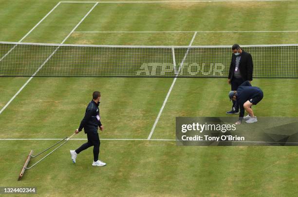 Ground staff prepare centre court after a light rain shower during Day 6 of The cinch Championships at The Queen's Club on June 19, 2021 in London,...