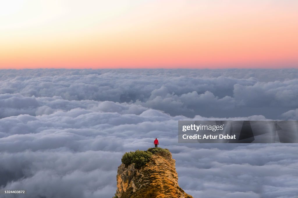 Stunning panoramic view on the top mountains with hiker and the cloudscape.