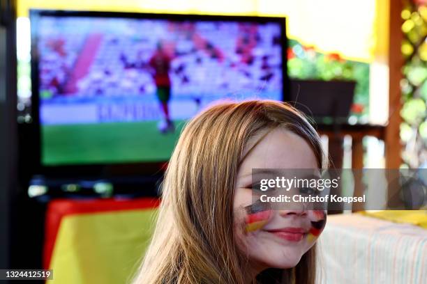 Young fan smiles during the UEFA EURO 2020 match between Germany and Portugal at garden plot Hohe Birk on June 19, 2021 in Essen, Germany. Due to...