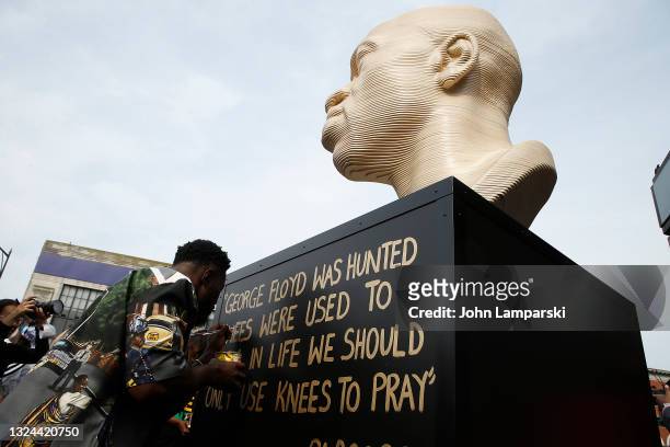An artist paints an inscription during the unveiling of the George Floyd memorial as New York City Honors Juneteenth Holiday on June 19, 2021 in the...