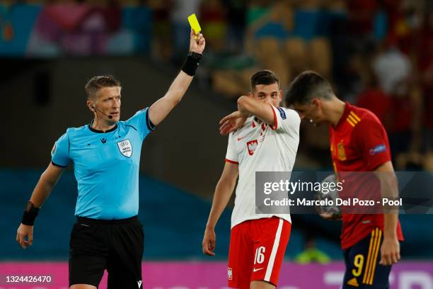 Match Referee, Daniele Orsato shows a yellow card to Kamil Jozwiak of Poland during the UEFA Euro 2020 Championship Group E match between Spain and...
