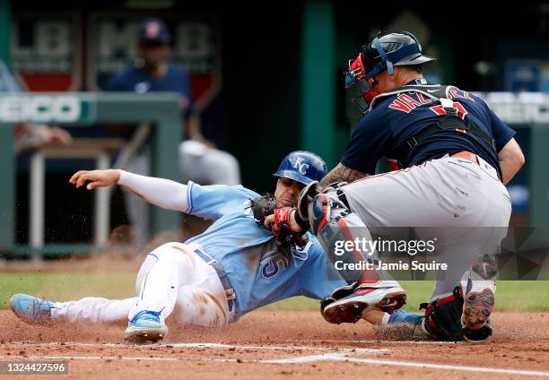 Whit Merrifield of the Kansas City Royals is tagged out at home plate by catcher Christian Vazquez of the Boston Red Sox during the 1st inning of the...