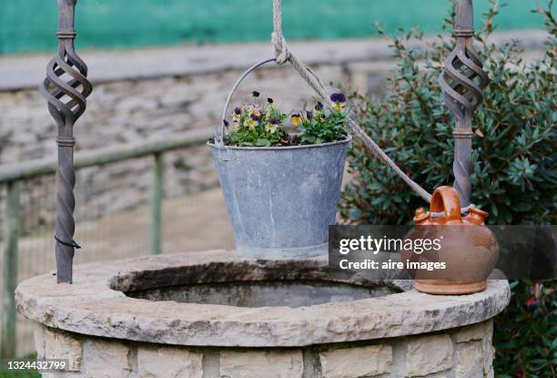 old cistern to extract water in the field. - metal bucket photos et images de collection