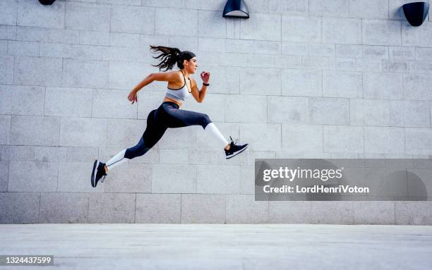 woman athlete jumping during exercising - high up stock pictures, royalty-free photos & images