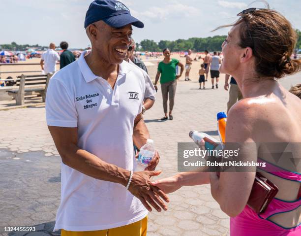 New York City Democratic Party mayoral candidate Eric Adams greets a beachgoer as he campaigns during the new Federal holiday Juneteenth at Orchard...