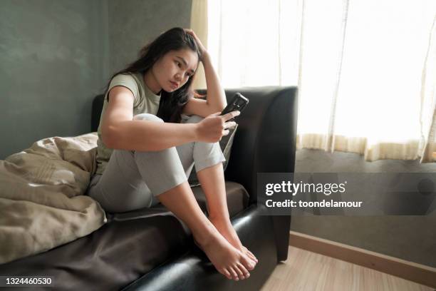 asia woman feeling sad in the bedroom. - millenial woes stock pictures, royalty-free photos & images