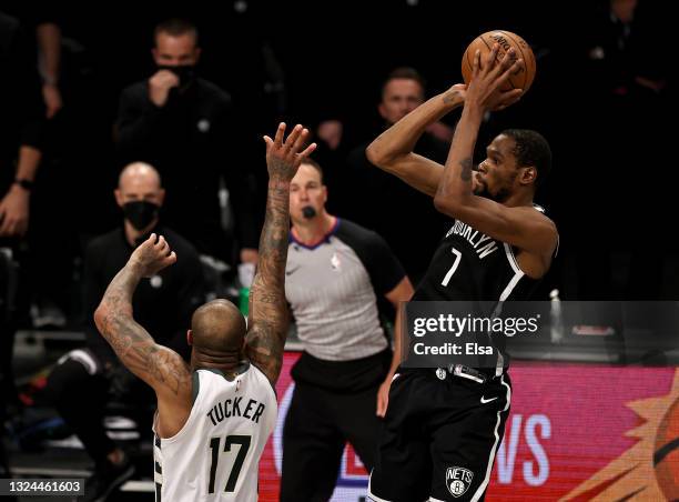 Kevin Durant of the Brooklyn Nets takes a shot to tie the game and force overtime as P.J. Tucker of the Milwaukee Bucks defends in the final seconds...