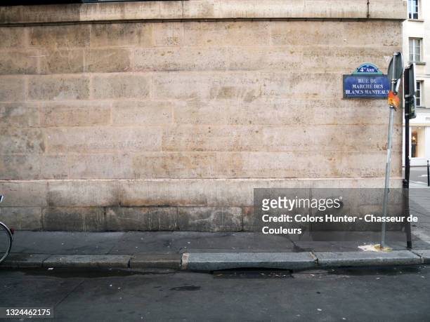 old stone wall and street in the marais in paris - städtische straße stock-fotos und bilder