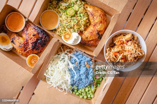 table top view malaysian food nasi kerabu, nasi ulam and ayam percik in recycled paper container with sauce - asian food stock pictures, royalty-free photos & images