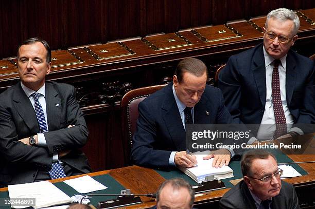 Italian Prime Minister Silvio Berlusconi writes as Foreign Affairs Minister, Franco Frattini and Economy Minister, Giulio Tremonti look on during the...