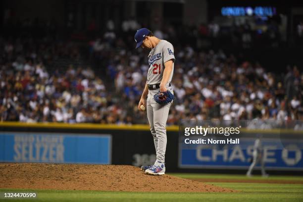 Walker Buehler of the Los Angeles Dodgers hangs his head just before getting taken out of the game by manager Dave Roberts in the eighth inning after...