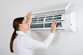 Businesswoman Checking Air Conditioner