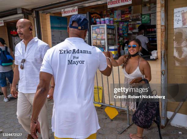 New York City Democratic Party mayoral candidate Eric Adams greets a beachgoer as he campaigns during the new Federal holiday Juneteenth at Orchard...