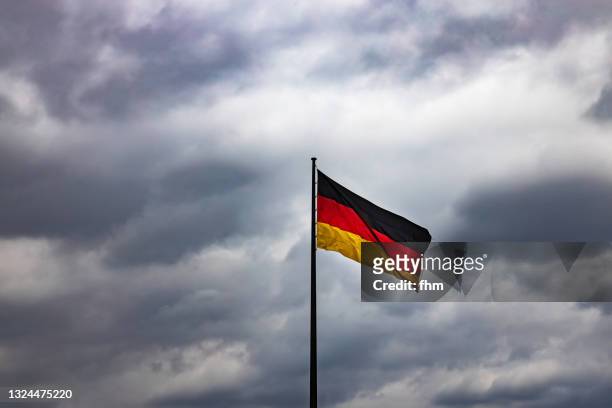 german flag with dramatic sky (berlin, germany) - german flag wallpaper stock pictures, royalty-free photos & images