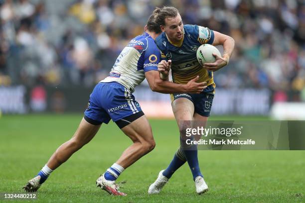 Clinton Gutherson of the Eels is tackled by Jake Averillo of the Bulldogs during the round 15 NRL match between the Parramatta Eels and the...