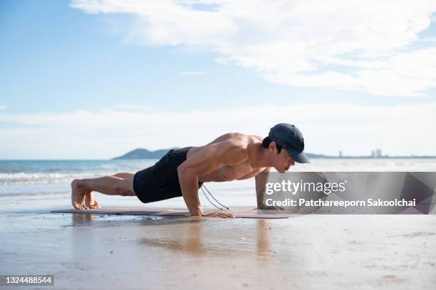 a man workout on the beach - flexiones fotografías e imágenes de stock