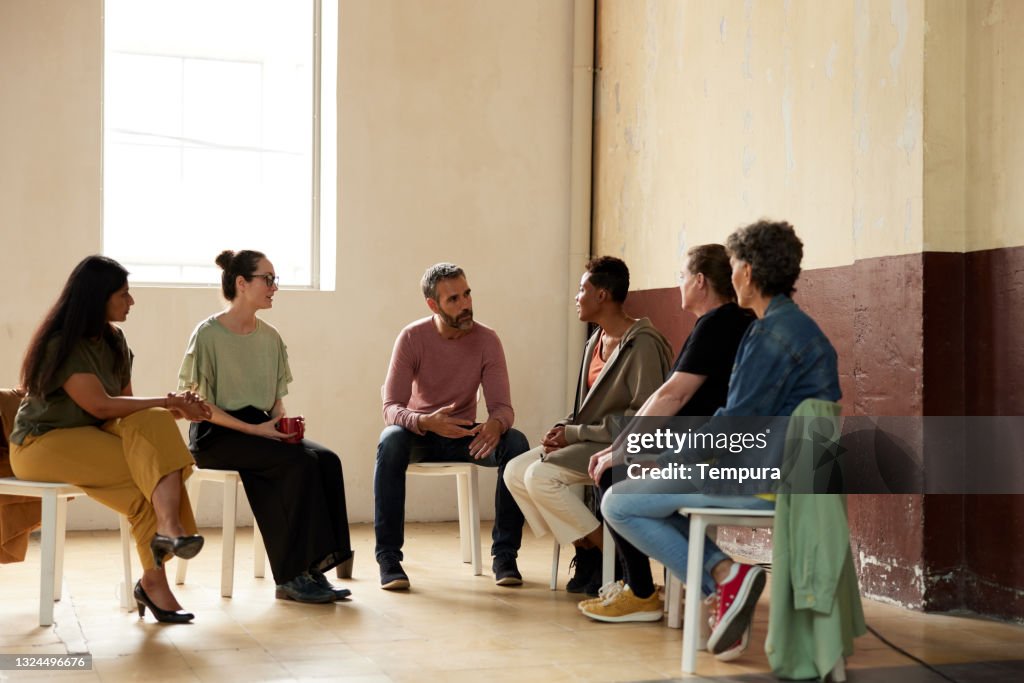 Alcoholics Anonymous group therapy sitting down.