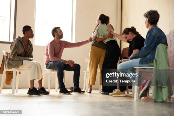 comforting and hugging a depressed colleague at group therapy. - indian society and daily life imagens e fotografias de stock