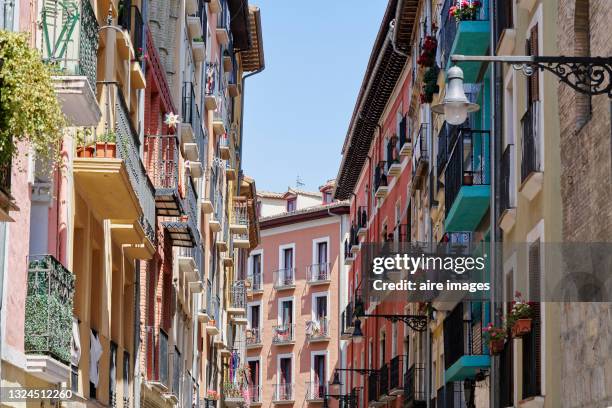 streets of the old town of pamplona with its decorated balconies under the blue sky. - pamplona fotografías e imágenes de stock