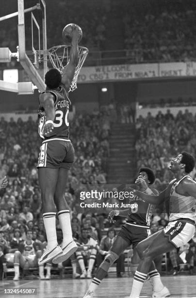 Philadelphia 76ers George McGinnis dunks the ball during an NBA basketball game against the Denver Nuggets at McNichols Arena on January 30, 1977 in...