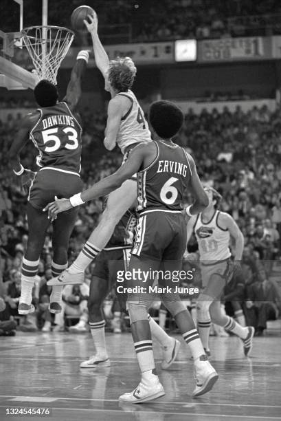 Denver Nuggets center Dan Issel dunks the ball over Philadelphia 76ers center Darryl Dawkins during an NBA basketball game at McNichols Arena on...