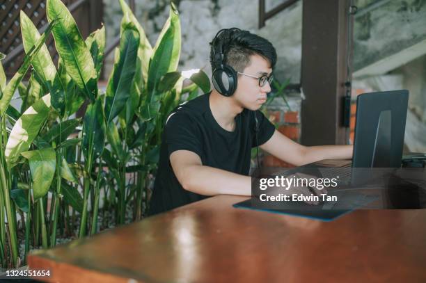 asian chinese young male studying at home using laptop and headphone - mouse pad stock pictures, royalty-free photos & images