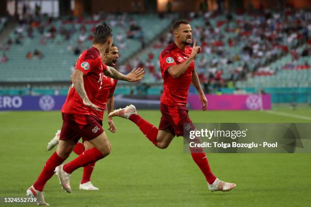 Haris Seferovic of Switzerland celebrates with teammates Steven Zuber and Ricardo Rodriguez after scoring their team's first goal during the UEFA...