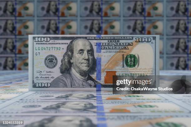 3d illustration of standing hundred dollar banknote. large sheets of us dollar bills in background. - billet de 100 dollars américains photos et images de collection