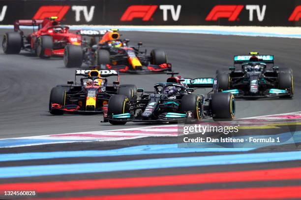 Lewis Hamilton of Great Britain driving the Mercedes AMG Petronas F1 Team Mercedes W12 leads Max Verstappen of the Netherlands driving the Red Bull...