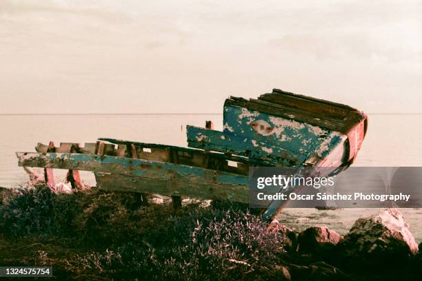 old wooden fishing boat in front of the sea - forsaken film stock pictures, royalty-free photos & images