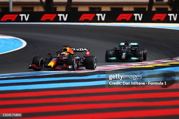 Max Verstappen of the Netherlands driving the Red Bull Racing RB16B Honda leads Lewis Hamilton of Great Britain driving the Mercedes AMG Petronas F1...