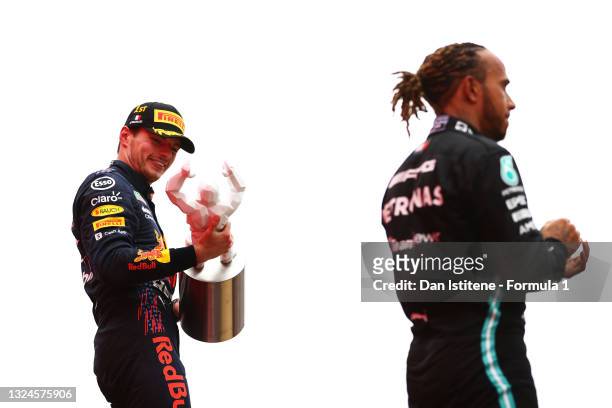 Race winner Max Verstappen of Netherlands and Red Bull Racing celebrates on the podium next to second placed Lewis Hamilton of Great Britain and...