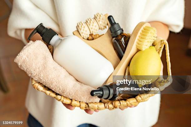 body and face care beauty bath set. lotion, essential oil, cream, massage brushes and anti-cellulite in a basket in the hands of a young woman. - hair products ストックフォトと画像