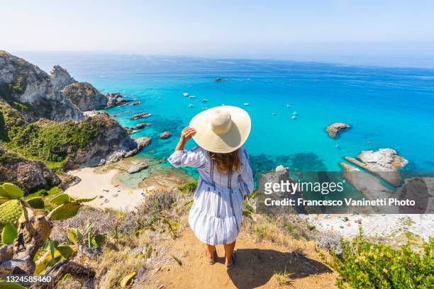 woman in capo vaticano, above the beaches of praia i focu, calabria, italy. - kalabrien stock-fotos und bilder