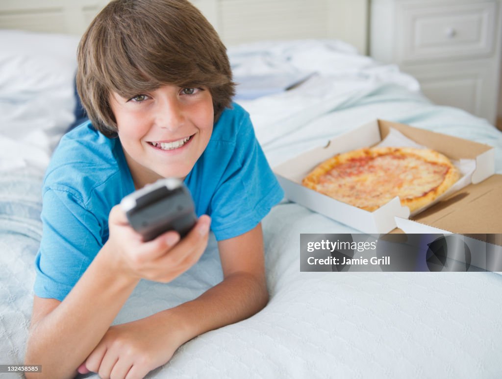 Boy watching TV with pizza