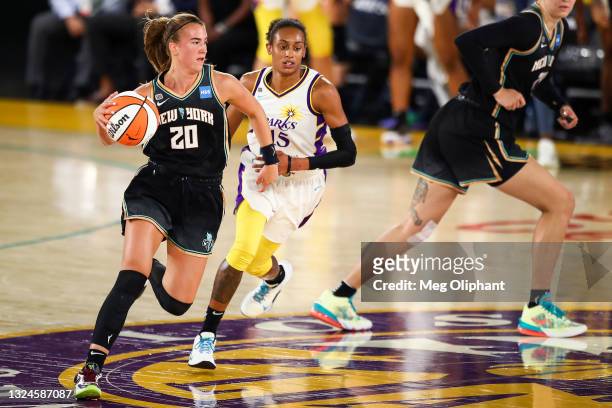 Guard Sabrina Ionescu of the New York Liberty handles the ball defended by guard Brittney Sykes of the Los Angeles Sparks in the first half at Los...
