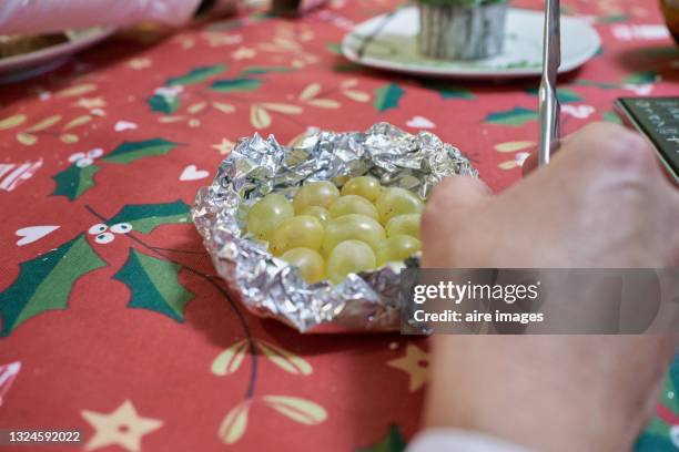 new year's eve traditions. latin american and spanish new year traditional. funny ritual to eat twelve 12 grapes for good luck at midnigth. - new years eve clock stock pictures, royalty-free photos & images