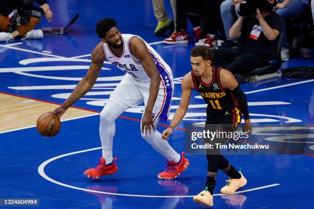Joel Embiid of the Philadelphia 76ers dribbles past Trae Young of the Atlanta Hawks during the first quarter during Game Seven of the Eastern...