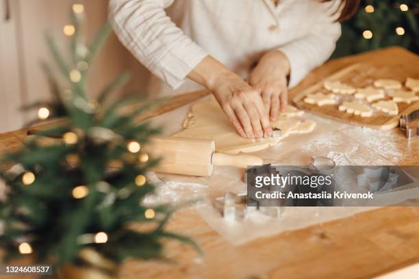 close up photo of woman's hand making holiday cookies at home. - flour christmas stock pictures, royalty-free photos & images