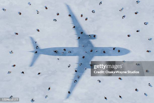 silhouette shadow of airplane over crowd of people - flugpassagier stock-fotos und bilder