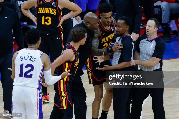 Tobias Harris of the Philadelphia 76ers and Trae Young, head coach Nate McMillan and John Collins of the Atlanta Hawks speak with referees James...