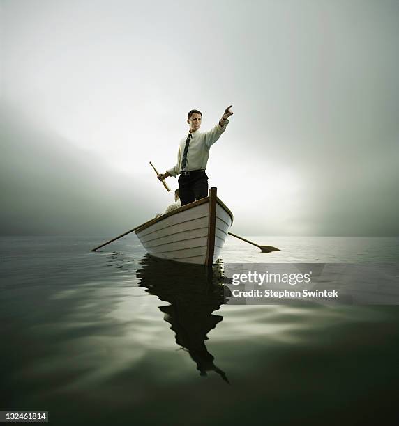 man in bow of boat pointing - bateau à rames photos et images de collection