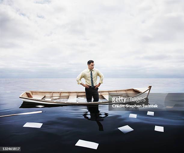 businessman in a sinking boat - crisi foto e immagini stock