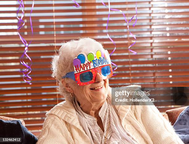 senior woman with birthday glasses on - senior woman birthday stock pictures, royalty-free photos & images