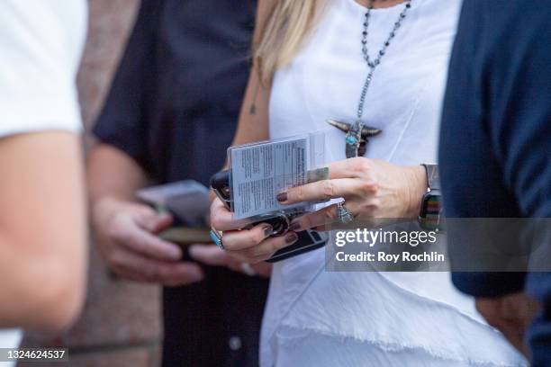 Person presents her proof of vaccination while standing in line for the Foo Fighters show as Madison Square Garden reopens with the first full...